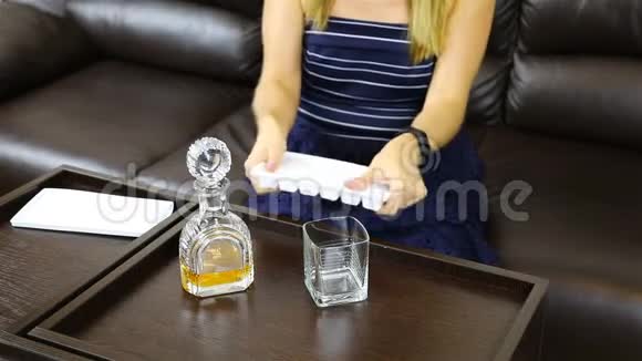 女孩在杯子里加了冰块用酒器倒了酒视频的预览图