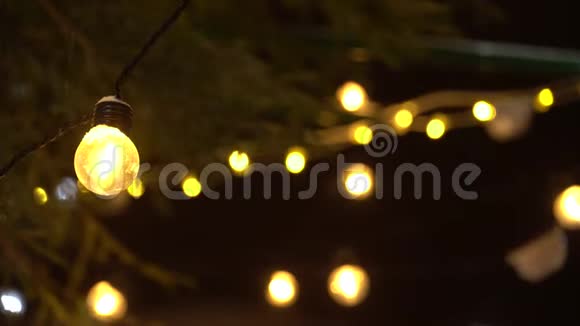 在闪烁的灯光的背景下特写新年花环的灯泡和小雪圣诞节模糊4K超高清视频的预览图