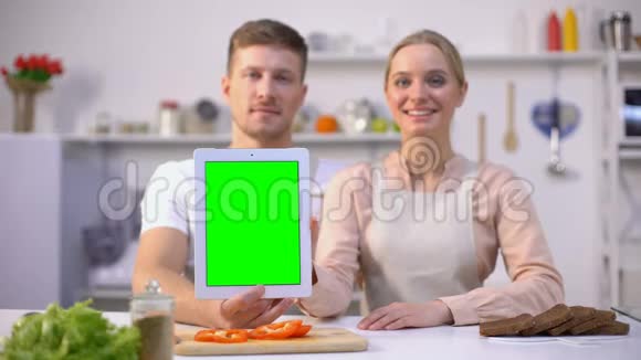 双手拿着绿色屏幕的平板电脑竖起大拇指美味的食谱应用程序视频的预览图