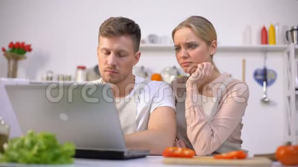 一对夫妇在网上阅读食物食谱在烹饪上遇到麻烦视频的预览图