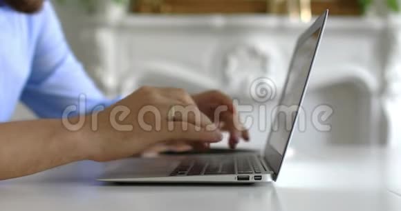 手在电脑键盘上打字商人在家里用笔记本电脑视频的预览图