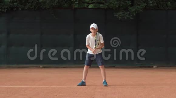 网球运动精神野心勃勃的孩子专注于比赛和球拍在红场上击球视频的预览图