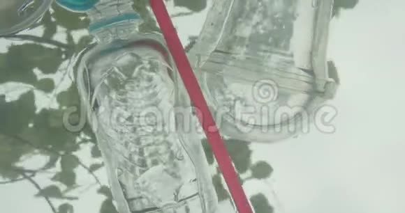 男手清理塑料瓶和垃圾中的河水的特写镜头视频的预览图