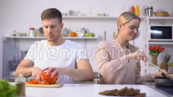 有趣的男人拿着胡椒片当眼镜和妻子在厨房里玩得很开心视频的预览图