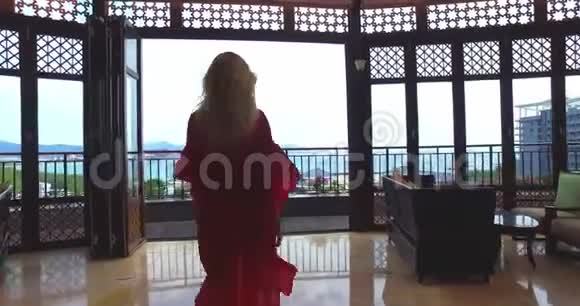 穿着红裙子走出酒店房间的女人视频的预览图