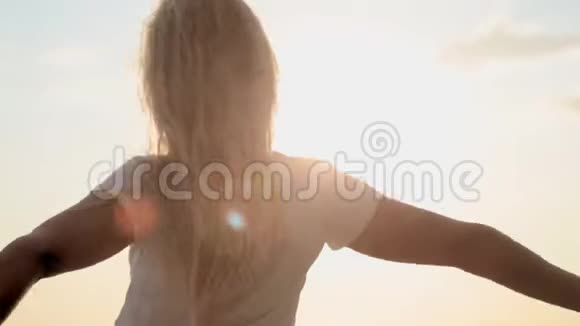 在日出的背景下自由快乐的女人举起手臂看太阳视频的预览图