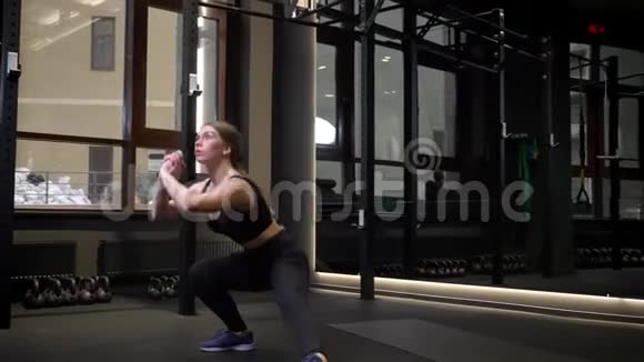 年轻有动力的运动女孩在健身房深蹲视频的预览图