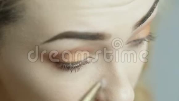自信的年轻女人用刷子把眼影涂在眼睑上漂亮的女孩化妆把化妆品涂在脸上视频的预览图