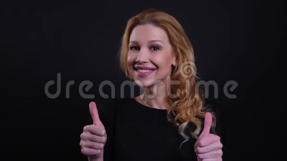 一幅成年红发女子的特写肖像她竖起大拇指开心地笑着看着摄像机视频的预览图