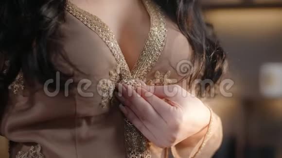 性感的女人解开她夜装的领口把她的手放在上面穿夜装的女人刺绣的衣服视频的预览图