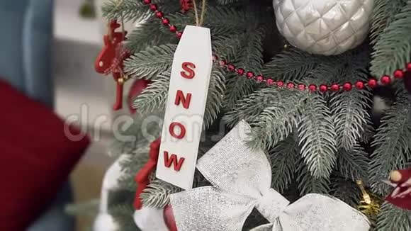 装饰着雪银亮丝带松果和红色花环的节日圣诞树视频的预览图