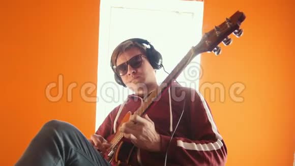 一个戴着眼镜的男人在演播室弹吉他视频的预览图