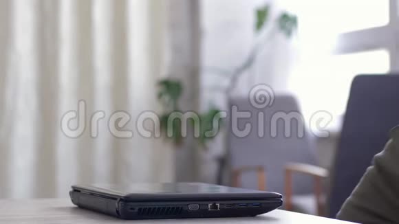 男人手打开笔记本电脑在键盘上输入文字然后在工作场所关闭电脑视频的预览图
