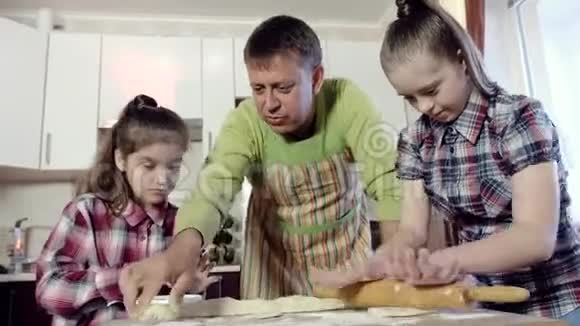 父亲教他的两个女儿如何擀面团其中一个女儿患有唐氏综合症视频的预览图