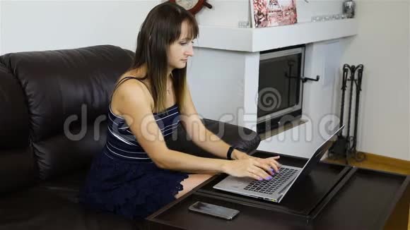 在笔记本电脑上工作的商务女士手中的智能手机视频的预览图