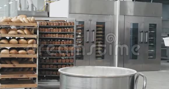 面包厂的老厨师在工业容器里准备面团他在背景面包店里加入一些面粉视频的预览图