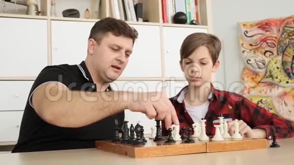 父亲和儿子正在下棋一边笑着一边在家里玩慢动作视频的预览图