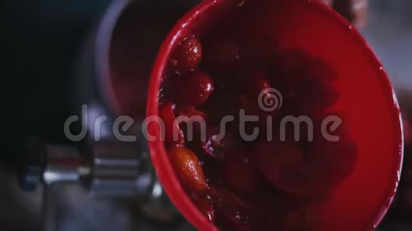 一个老年妇女的特写镜头一个榨汁机的手柄来接收番茄汁视频的预览图