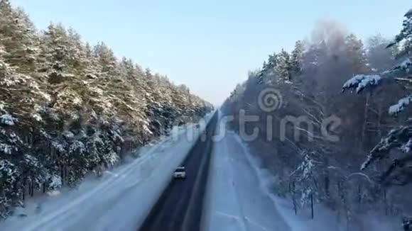 冬季景观道路及积雪覆盖树木林间公路的鸟瞰图雪树枝的景色视频的预览图