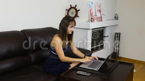 女孩在客厅的沙发上用笔记本电脑工作视频的预览图
