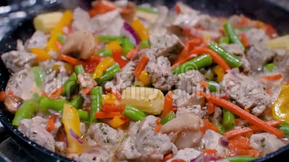 近距离观看五颜六色的热气腾腾的蔬菜煎锅被混合和抛出烹饪过程健康食品素食视频的预览图
