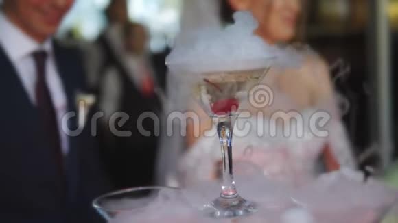 婚礼庆典用的希尔香槟在新娘和新郎模糊的背景下从干冰中吸出视频的预览图