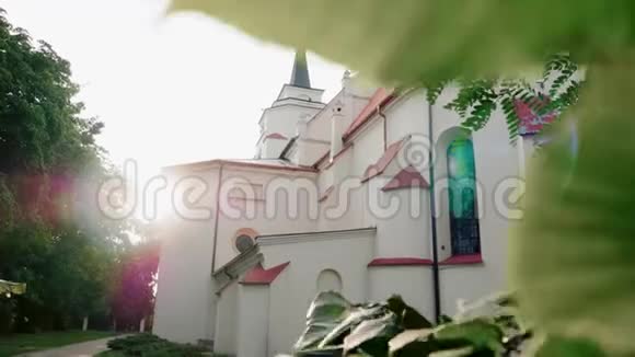太阳透过树叶照射在树上的罗马天主教堂视频的预览图