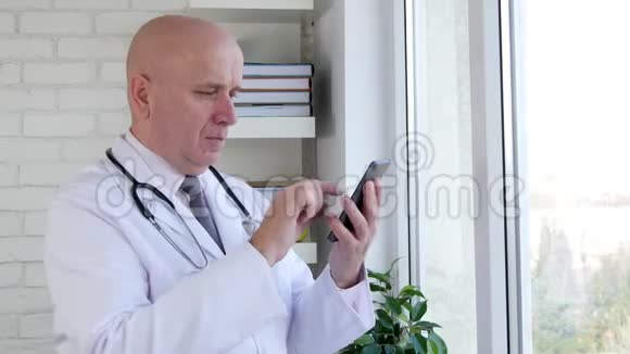 医院柜子里的医生在手机上看到好消息打手势表示高兴视频的预览图