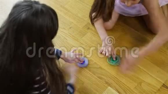 女孩们在地板上旋转蓝色和绿色的旋转体视频的预览图