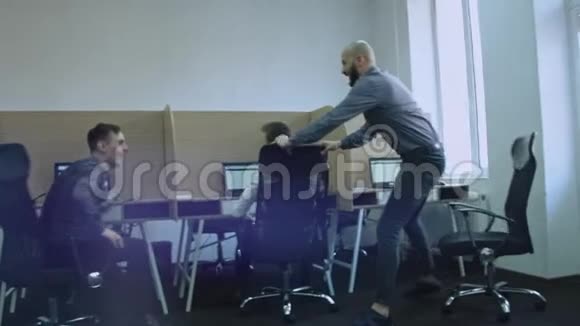 令人兴奋的不同员工在办公室里一起玩在工作中坐在椅子上享受休息庆祝企业视频的预览图