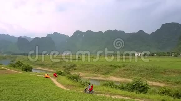 男人和女人骑着摩托车沿着河边狭窄的地面公路视频的预览图