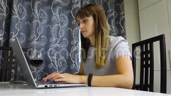 一个穿着商务服装的女人在家工作手提电脑视频的预览图