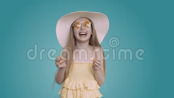 快乐的年轻白白白种人女孩留着长长的头发穿着黄色的连衣裙戴着夏帽对着镜头笑视频的预览图