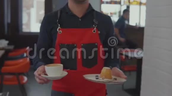 服务员正拿着咖啡和甜点给男顾客摆在桌子上视频的预览图