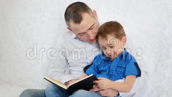 幸福家庭一位父亲和他的儿子正在读一本有趣的书视频的预览图