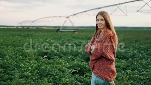 穿着老式连衣裙的年轻农民女孩走过田野农产品种植有机产品视频的预览图