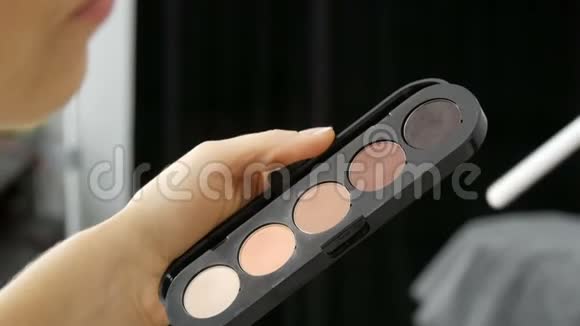 一位化妆师手中拿着各种米色的调色板这位化妆师是专业化妆师视频的预览图