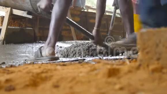 不可辨认的印度男子铲手工湿水泥在建筑工地的低角度视图当地建筑商视频的预览图