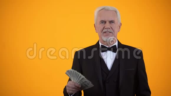快乐的老人穿着西装手里拿着美元竖起大拇指有商业收入视频的预览图