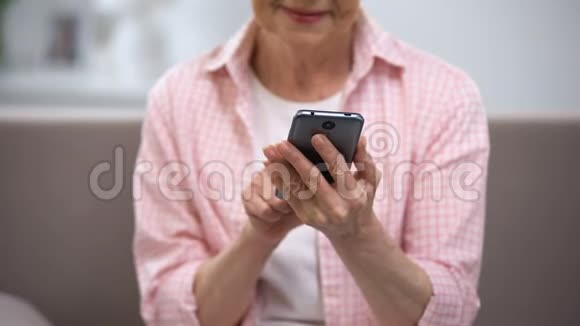 微笑老年妇女使用智能手机老年人应用程序技术视频的预览图