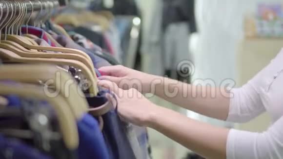商店里的衣服带裙子的衣架货物的选择广告的背景不同的颜色那个女孩视频的预览图