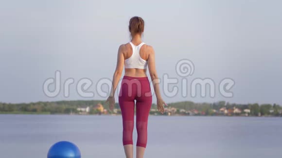 健身瑜伽运动女性与美丽的身材做瑜伽同时放松和享受精神平静户外视频的预览图