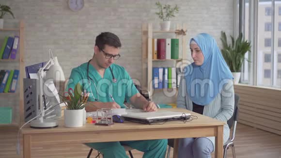 年轻的穆斯林妇女戴头巾在医生约会男人视频的预览图