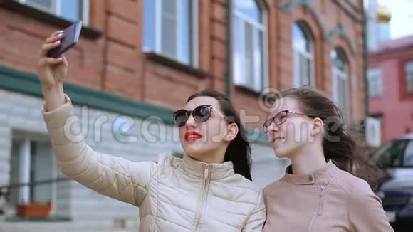 两个女孩带着自拍在城市里走来走去视频的预览图