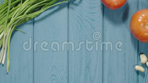 俯视图蓝色木桌上滚动的托蒂利奥尼面食葱番茄视频的预览图