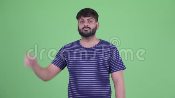 快乐的年轻胖胡子印度男人指着视频的预览图