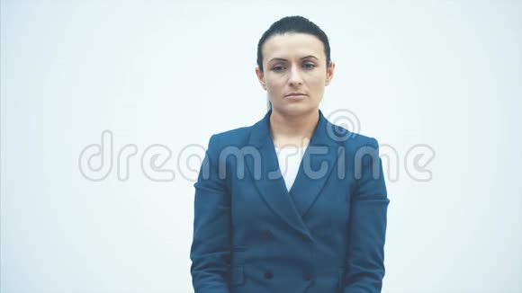 一个年轻的困倦的女老师站在白色的背景上在这段时间里保持白色时钟昏昏欲睡视频的预览图