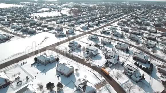 空中校车穿过白雪皑皑的居民区视频的预览图