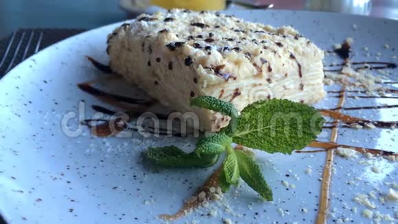 美味的甜点拿破仑奶油蛋糕的切片由膨化糕点制成放在餐馆或咖啡馆的桌子上的盘子上视频的预览图
