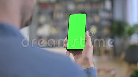 使用绿色锁屏智能手机的年轻人视频的预览图